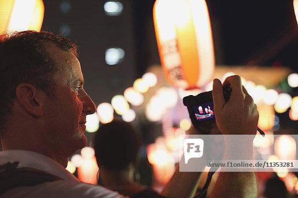 Caucasian man taking pictures at Japanese traditional Bon Odori festival