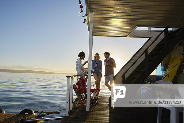 Young adult friends hanging out on summer houseboat on ocean