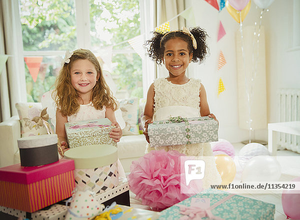 Portrait smiling girls holding birthday gifts