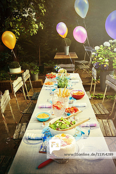 Ballons und Essen am Gartenparty-Terrassentisch