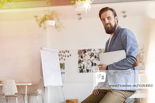 Portrait zuversichtlich männlichen Design-Profi halten Laptop im Büro