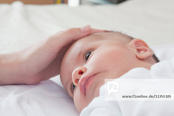 Mütter streicheln Baby Jungen Kopf