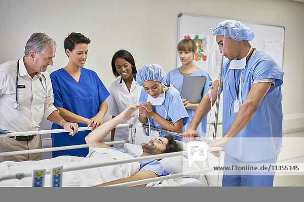 Ärzte und Krankenschwestern um den Patienten im Krankenhausbett