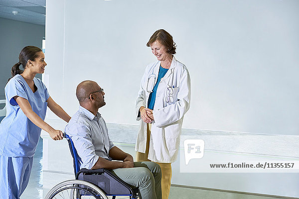 Doctor talking to man in wheelchair