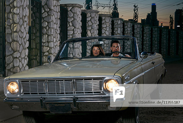 Paar fährt Cabriolet-Oldtimer bei Nacht  Los Angeles  Kalifornien  USA