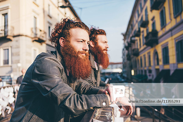 Junge männliche Hipster-Zwillinge mit roten Haaren und Bärten  die vom Stadtsteg aus gesehen werden.