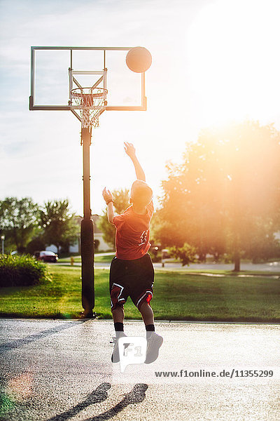 Junge schießt Basketball-Sprungwurf