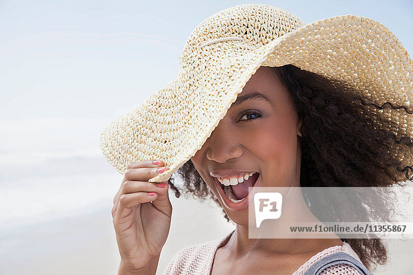 Junge Frau am Strand an einem windigen Tag
