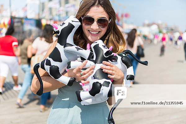 Couple holding cuddly toy cows smiling  Coney island  Brooklyn  New York  USA