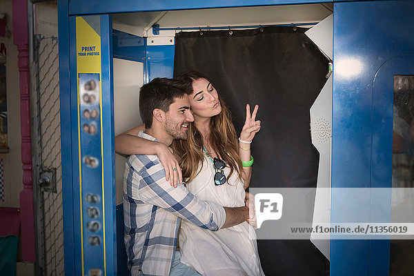 Couple in photo booth doing peace sign  Coney island  Brooklyn  New York  USA
