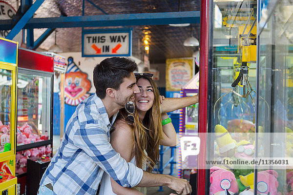 Couple at amusement park using arcade grabber  Coney island  Brooklyn  New York  USA