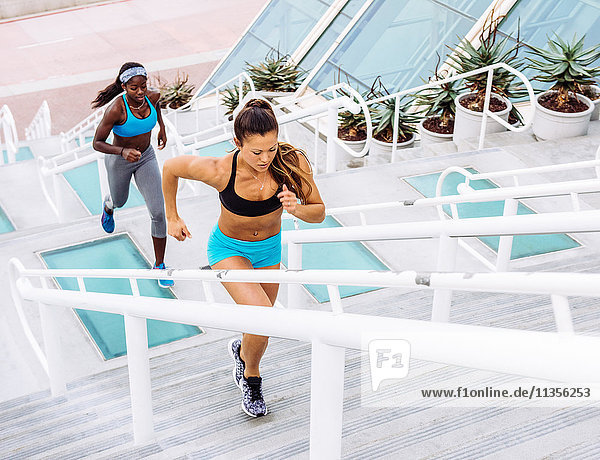 Side view of two women training  running up stairway at sport facility  downtown San Diego  California  USA