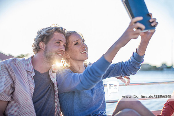 Junges Touristenpaar mit digitalem Tablet-Selfie auf Bootsfahrt  Kapstadt  Südafrika