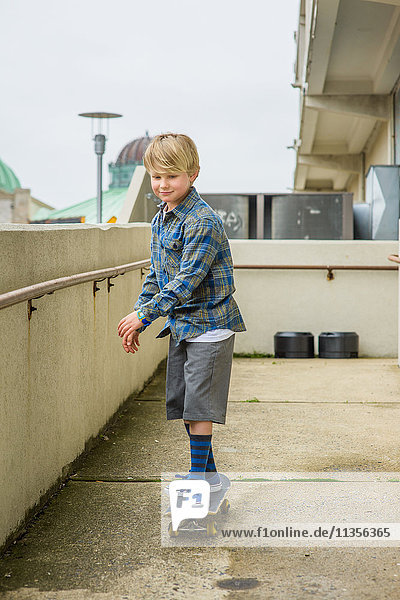 Boy skateboarding down parking lot ramp