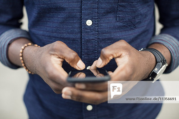 Midsection of man using mobile phone