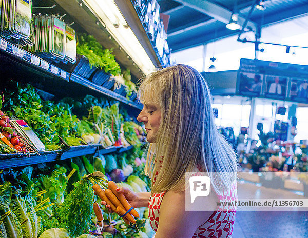 Frau kauft Gemüse im Supermarkt ein
