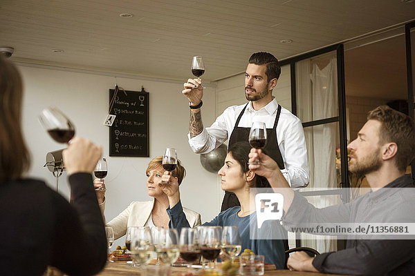 Der Mensch steht den Menschen bei und analysiert das Weinglas am Tisch.