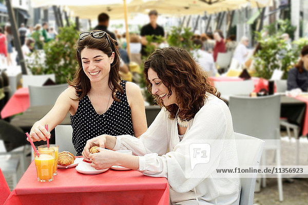 Zwei Frauen beim Plaudern und Frühstücken im Straßencafé  Mailand  Italien