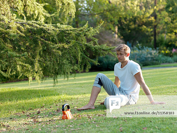 Young man relaxing on grass  taking a break from exercising