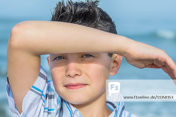 Porträt eines Jungen  der die Augen am Strand abschirmt  Asbury Park  New Jersey  USA