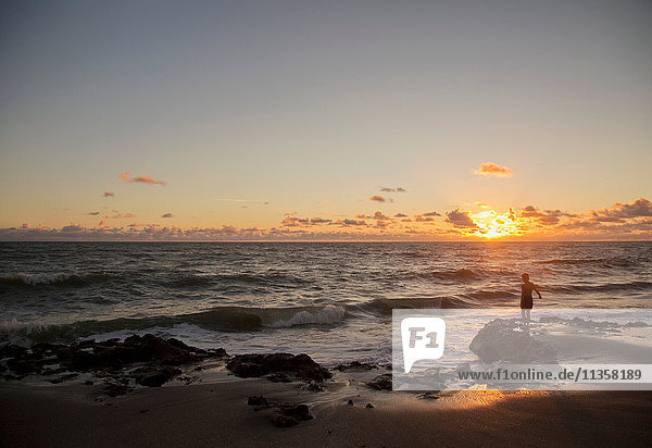 Boy looking out to sea at sunrise  Blowing Rocks Preserve  Jupiter Island  Florida  USA