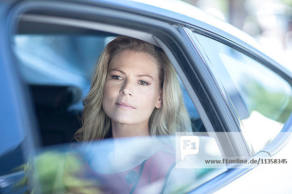 Businesswoman looking out of car window
