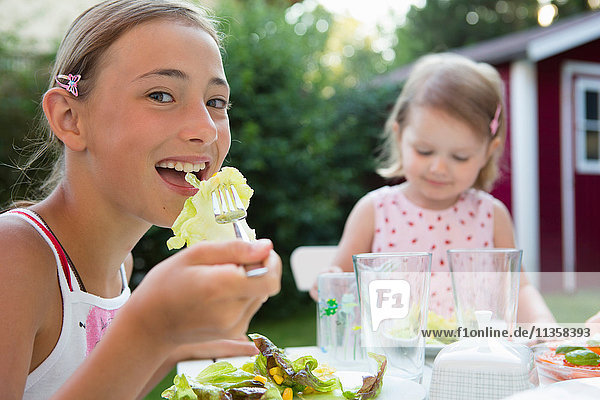 Portrait of girl eating salad in garden  Bavaria  Germany