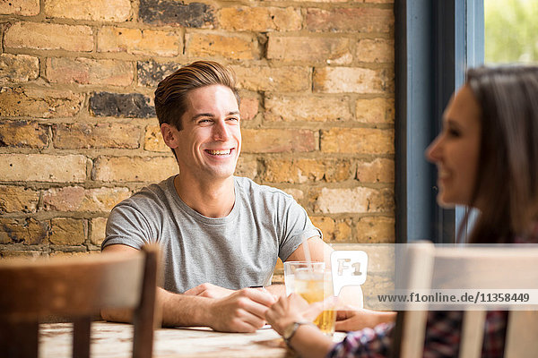 Young couple laughing and talking in bar