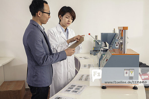 Techniker erklärt Druckmaschine für Manager in Druck- und Verpackungsfabrik  China