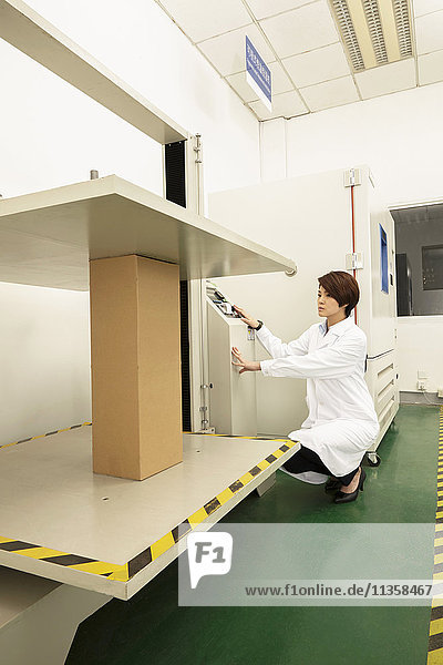 Weibliche Technikerin an einer Verpackungsmaschine in einer Druck- und Verpackungsfabrik  China