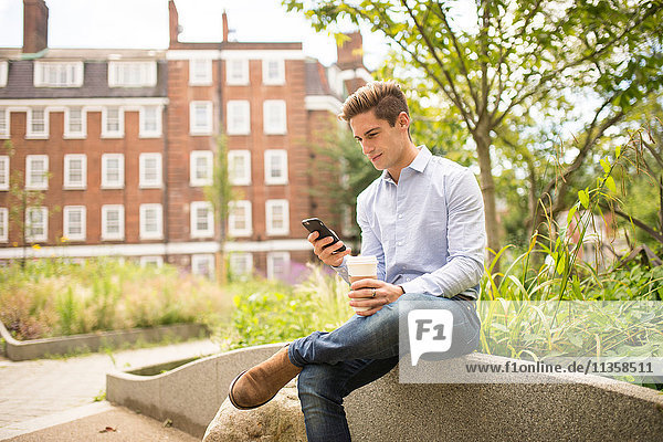 Geschäftsmann beim Lesen von Smartphone-Texten in der Stadt  London  UK