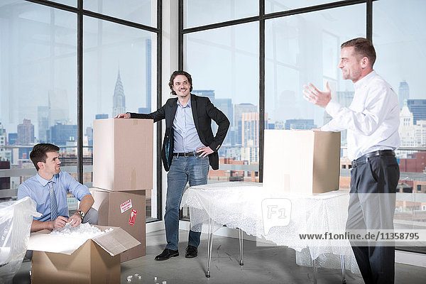Businessmen and businesswoman unpacking in office