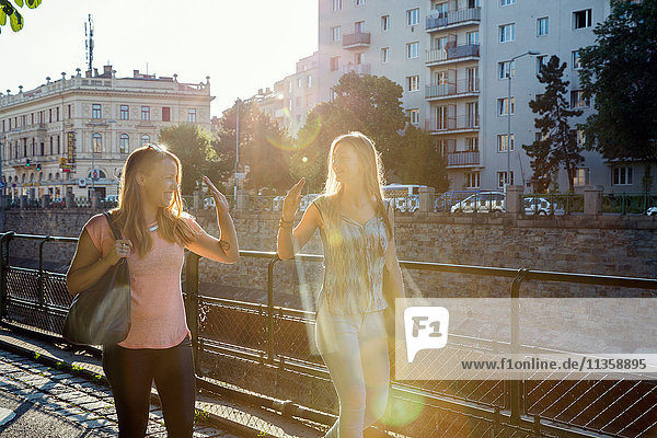 Zwei erwachsene Freundinnen geben sich gegenseitig ein High Fiving in der Stadt  Wien  Österreich