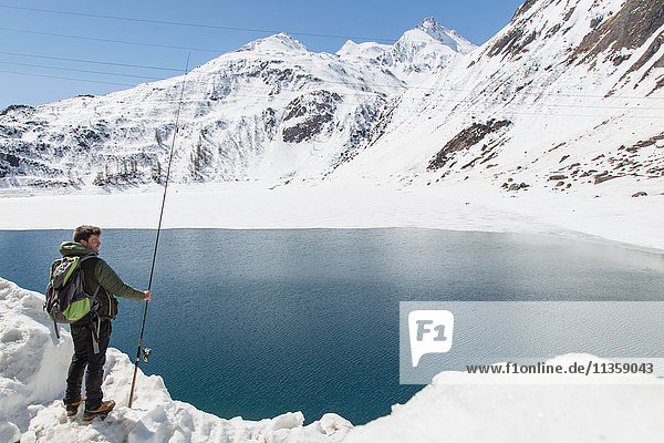 Mid adult man  fishing  Morasco lake  Morasco  Val Formazza  Piemonte  Italy