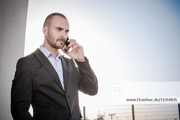Businessman outside office talking on smartphone  Cagliari  Sardinia  Italy