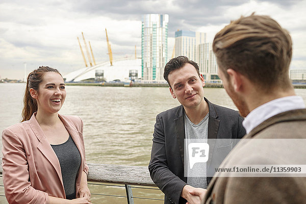 Young businesswoman and businessmen having discussion on waterfront  London  UK