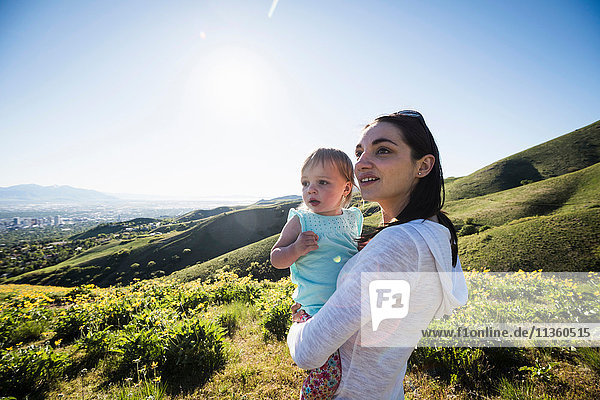 Mother holding young daughter  hiking the Bonneville Shoreline Trail in the Wasatch Foothills above Salt Lake City  Utah