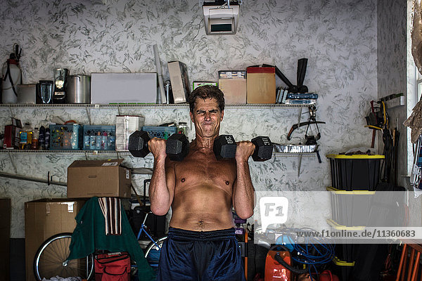 Mature man working out in garage  lifting weights