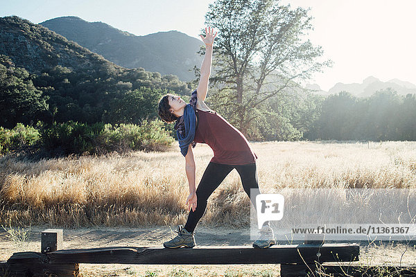 Woman by mountains doing stretching exercises  Malibu  California  USA