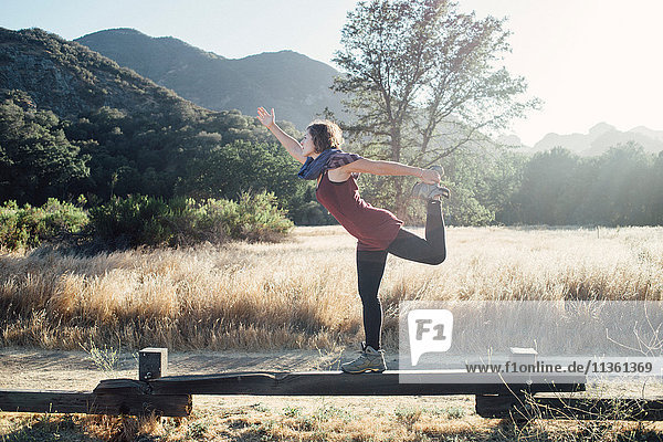 Woman by mountains doing stretching exercises  Malibu  California  USA