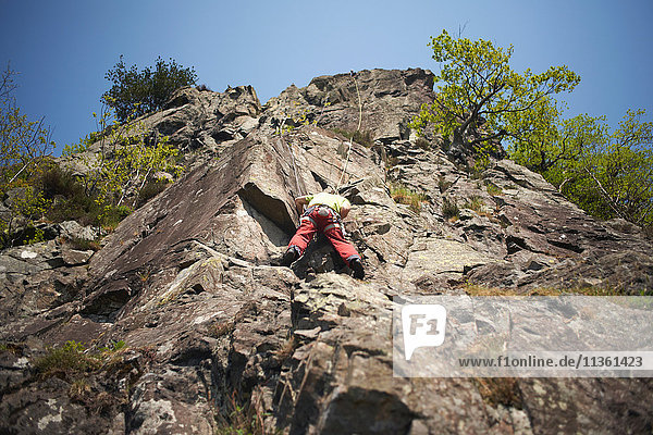 Low angle view of rock climber on rock face