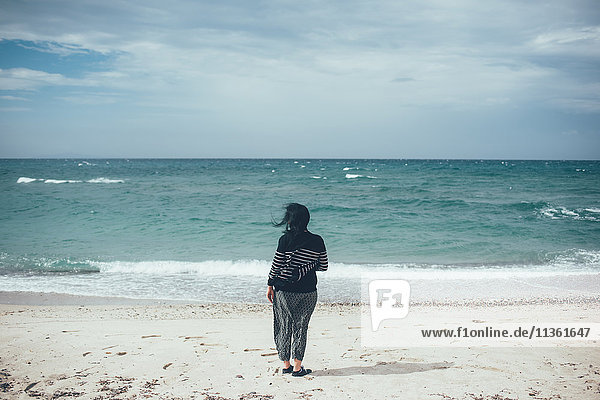 Rückansicht einer Frau am Strand mit Blick auf den Ozean  Sorso  Sassari  Italien