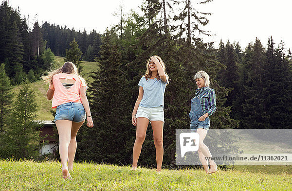 Three female adult friends playing in field  Sattelbergalm  Tirol  Austria