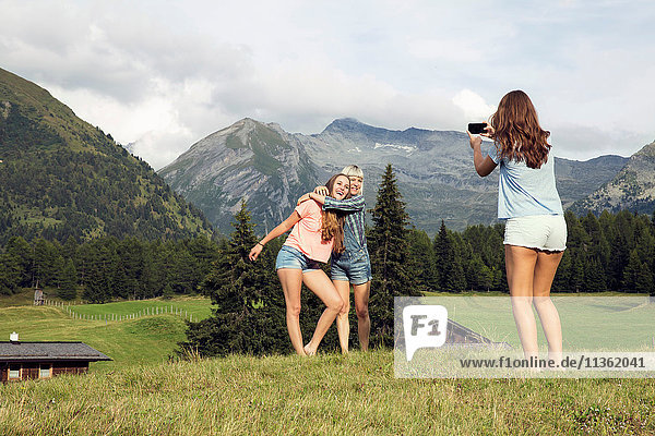 Junge Frau fotografiert Freundinnen in den österreichischen Alpen  Sattelbergalm  Tirol  Österreich