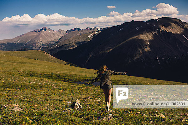 Frau balanciert auf Fels und Bergen  Rocky Mountain National Park  Colorado  USA