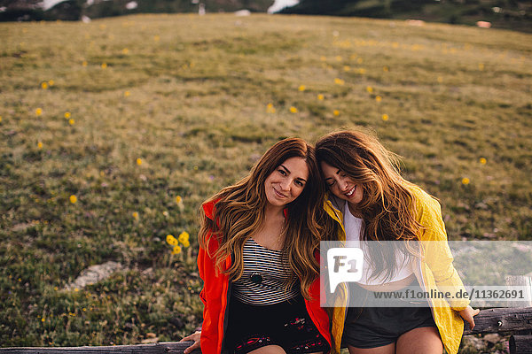 Freunde sitzen Seite an Seite und schauen lächelnd in die Kamera  Rocky Mountain National Park  Colorado  USA