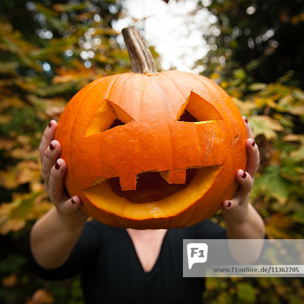 Woman holding carved pumpkin