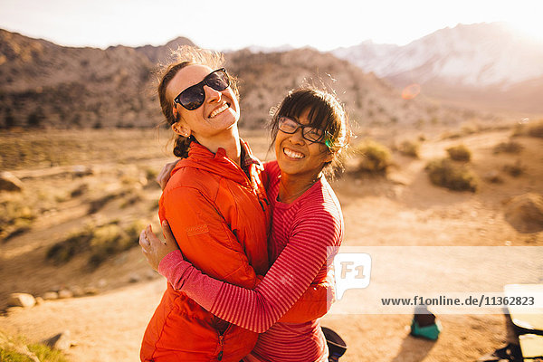 Freunde umarmen sich und schauen lächelnd in die Kamera  Buttermilk Boulders  Bishop  Kalifornien  USA