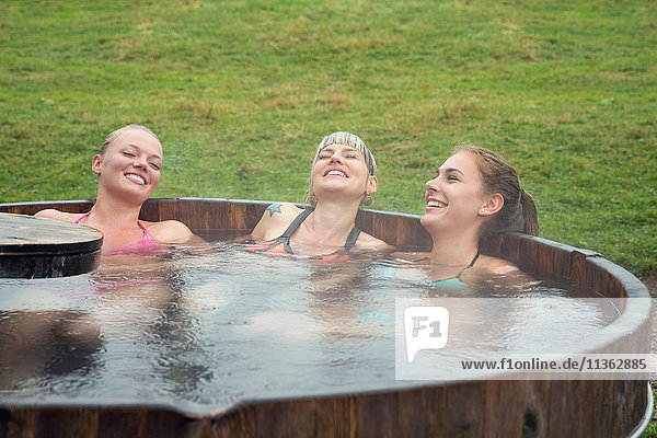 Drei Freundinnen lachen  während sie sich im Whirlpool entspannen