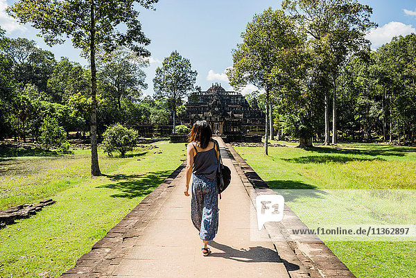Rear view of woman in garden of Phimeanakas temple Siem Reap Cambodia